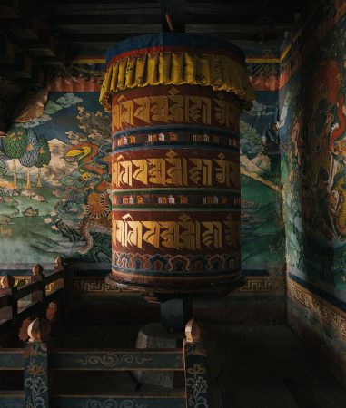 Gebetsmühle und buddhistische Fresken